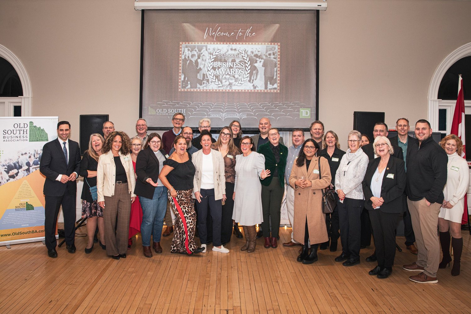 A large group of attendees posing together at a business awards event.